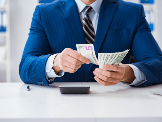 Man counting money at desk Man counting money at desk