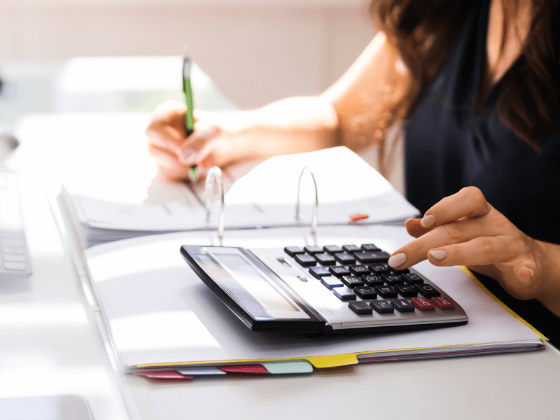 Lady Sitting at Desk Working and Typing on Calculator
