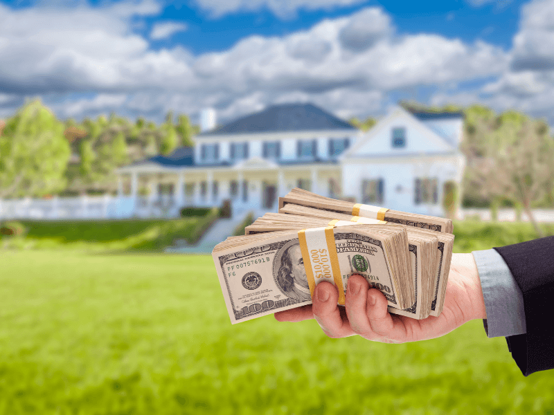 Person handing over cash in front of a home