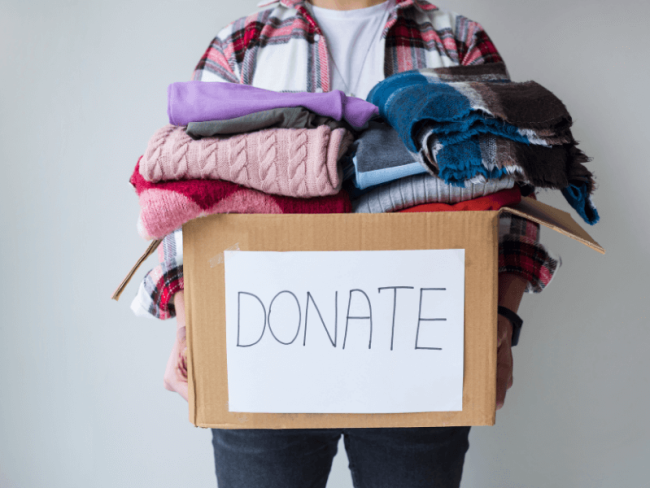 Picture of a person holding a box of donated clothing