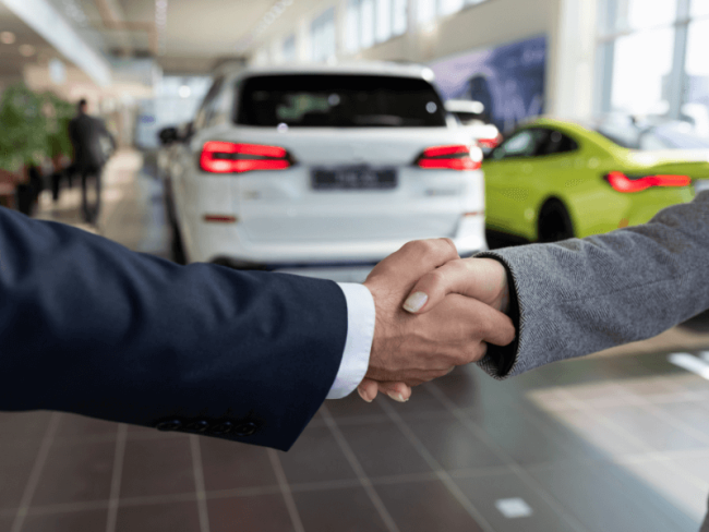 Picture of people shaking hands at a car dealership
