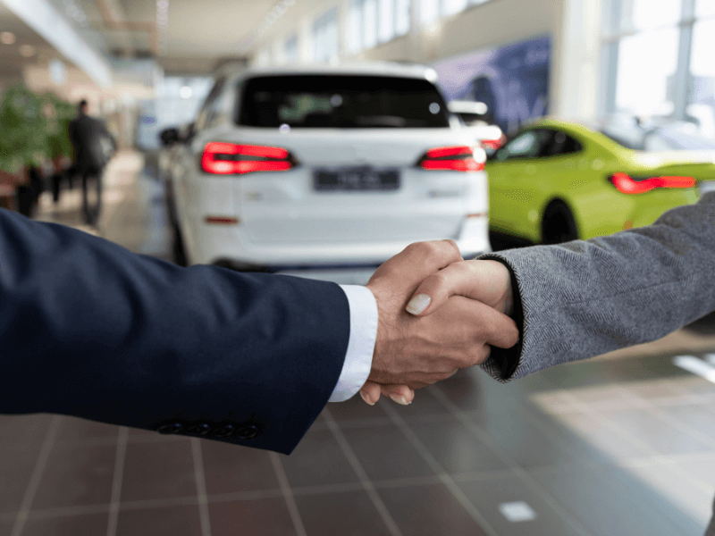 Picture of people shaking hands at a car dealership