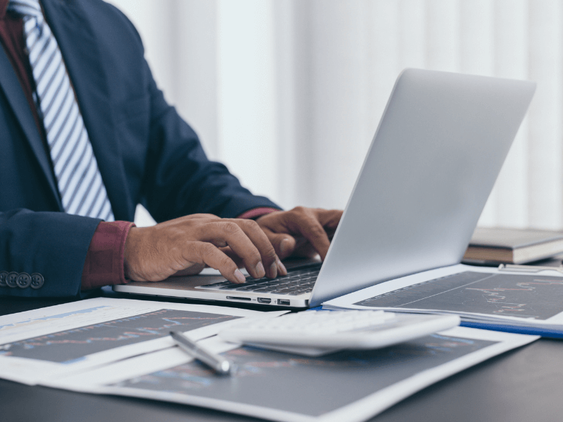 Picture of a person working at a desk on their laptop
